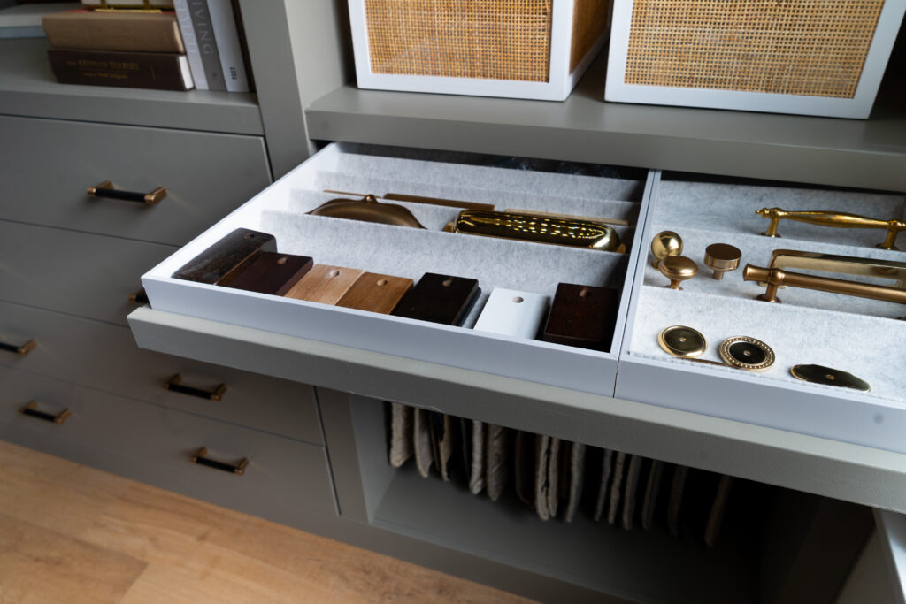 Interior design samples of cabinet hardware and furniture finishes.